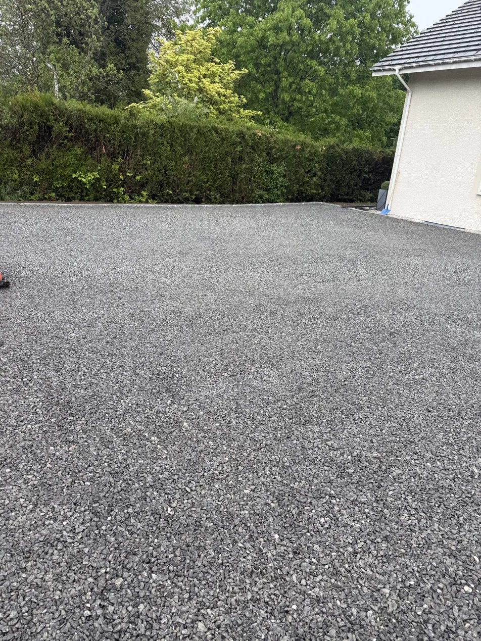 Grande cour en gravillon devant une maison